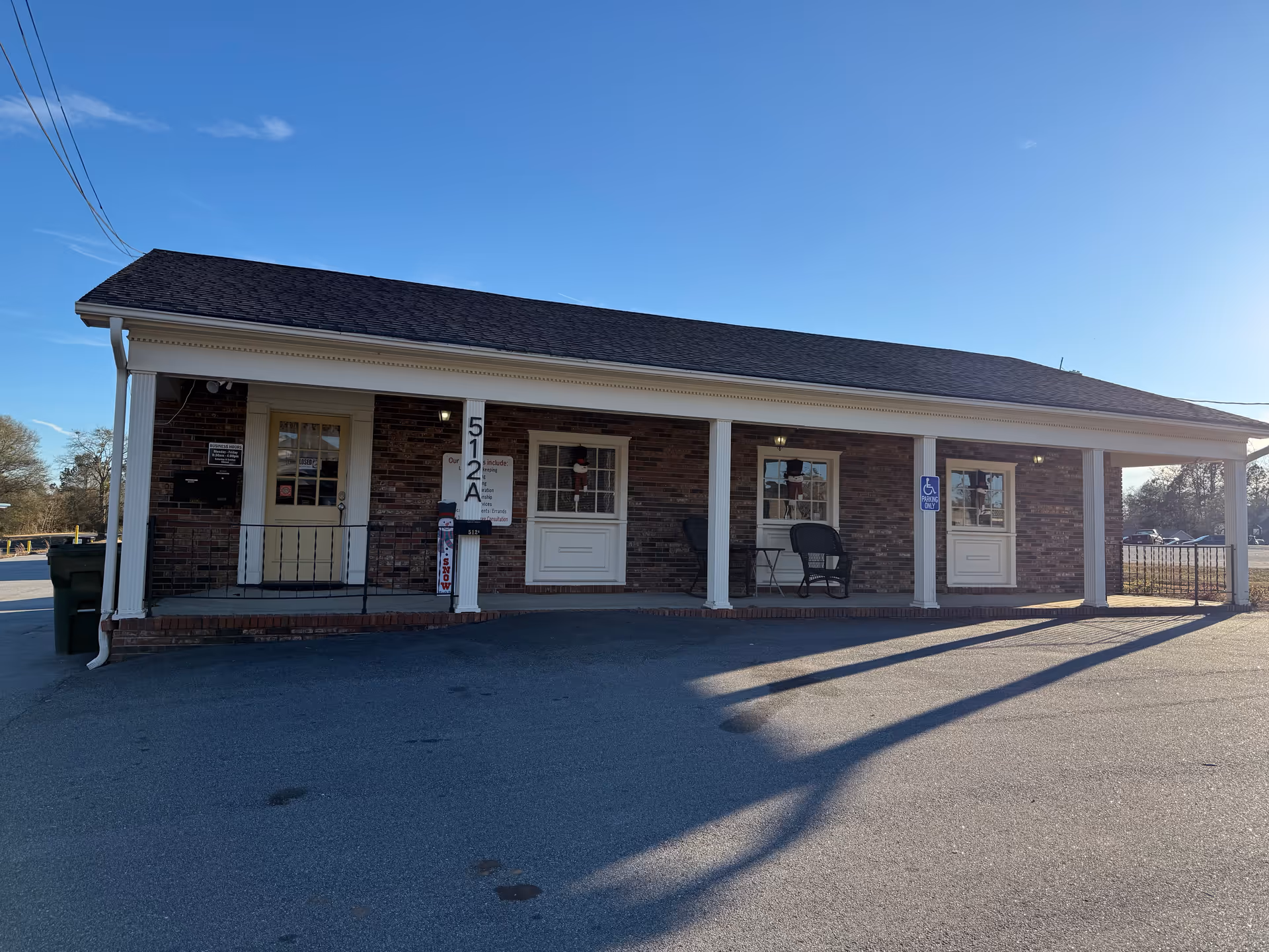 Front view of a single-story brick building with a covered porch and multiple doors.