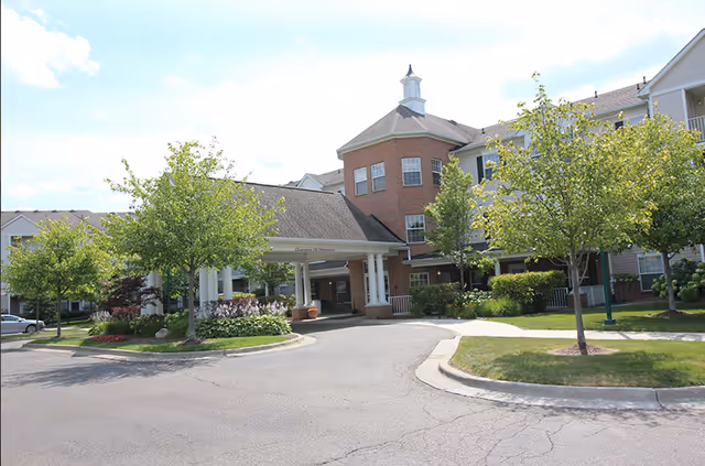 Exterior view of Village of Redford facility with entrance canopy and surrounding trees.