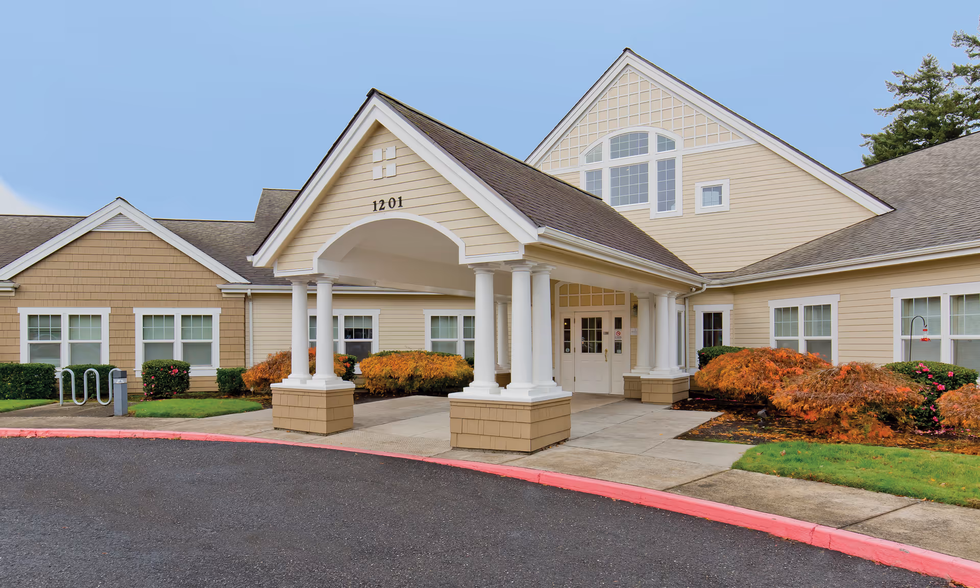 Exterior view of Brookdale Troutdale senior living facility entrance with columns and landscaping.