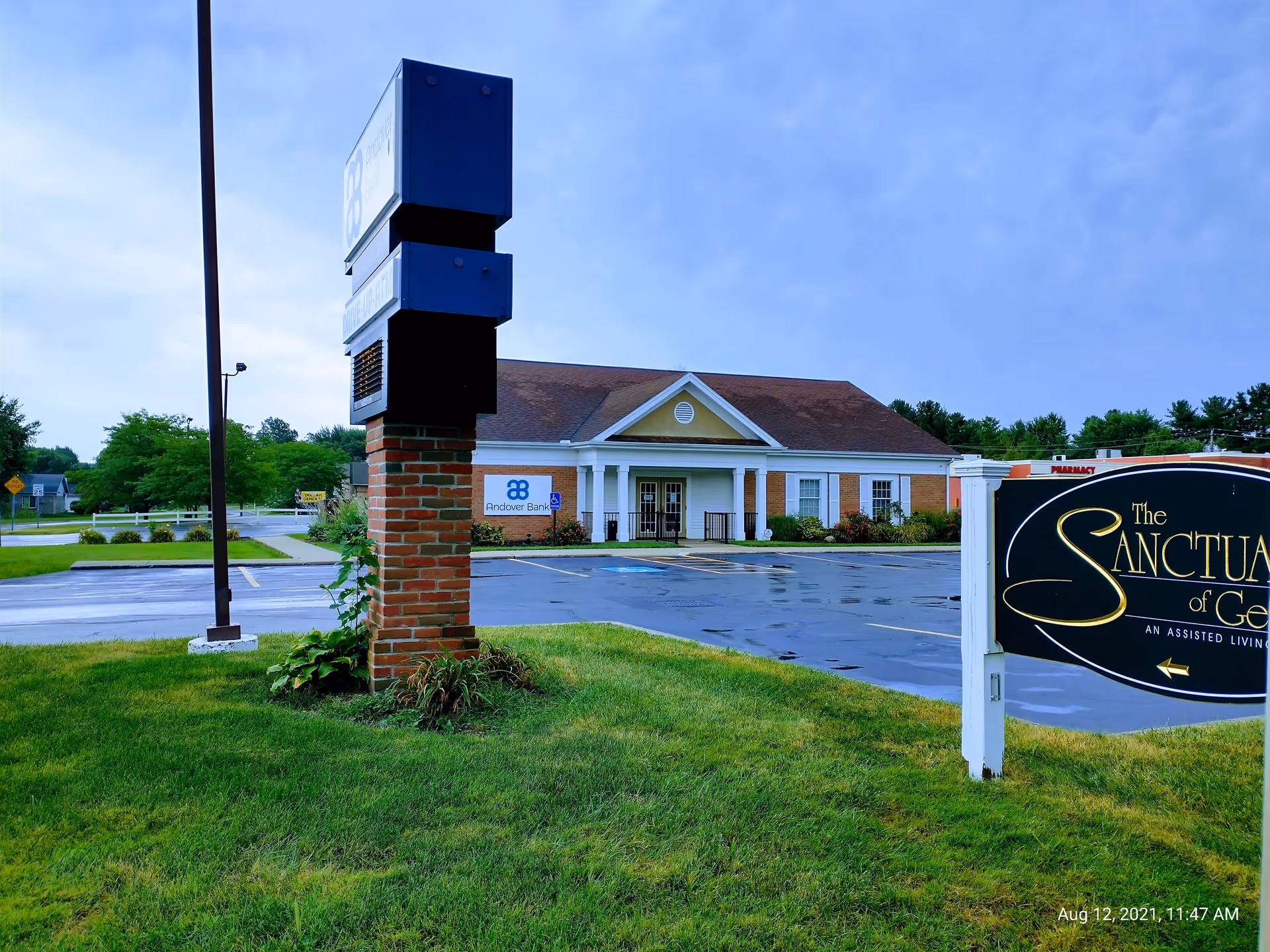 Exterior view of Sanctuary senior living facility with sign and brick-front entrance