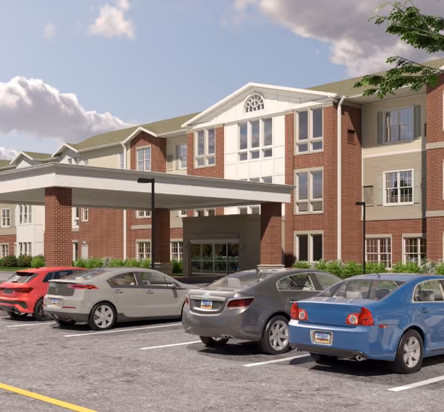 Exterior view of Harmony at Glasgow senior living facility with parked cars