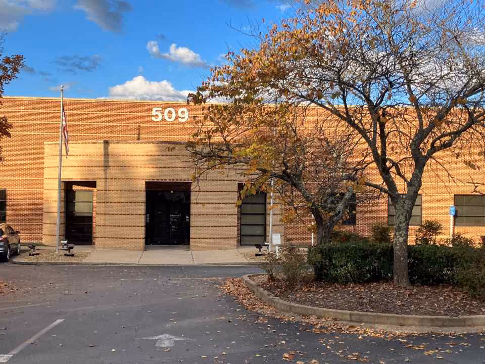Exterior brick building with 509, trees, and a parking lot in autumn.