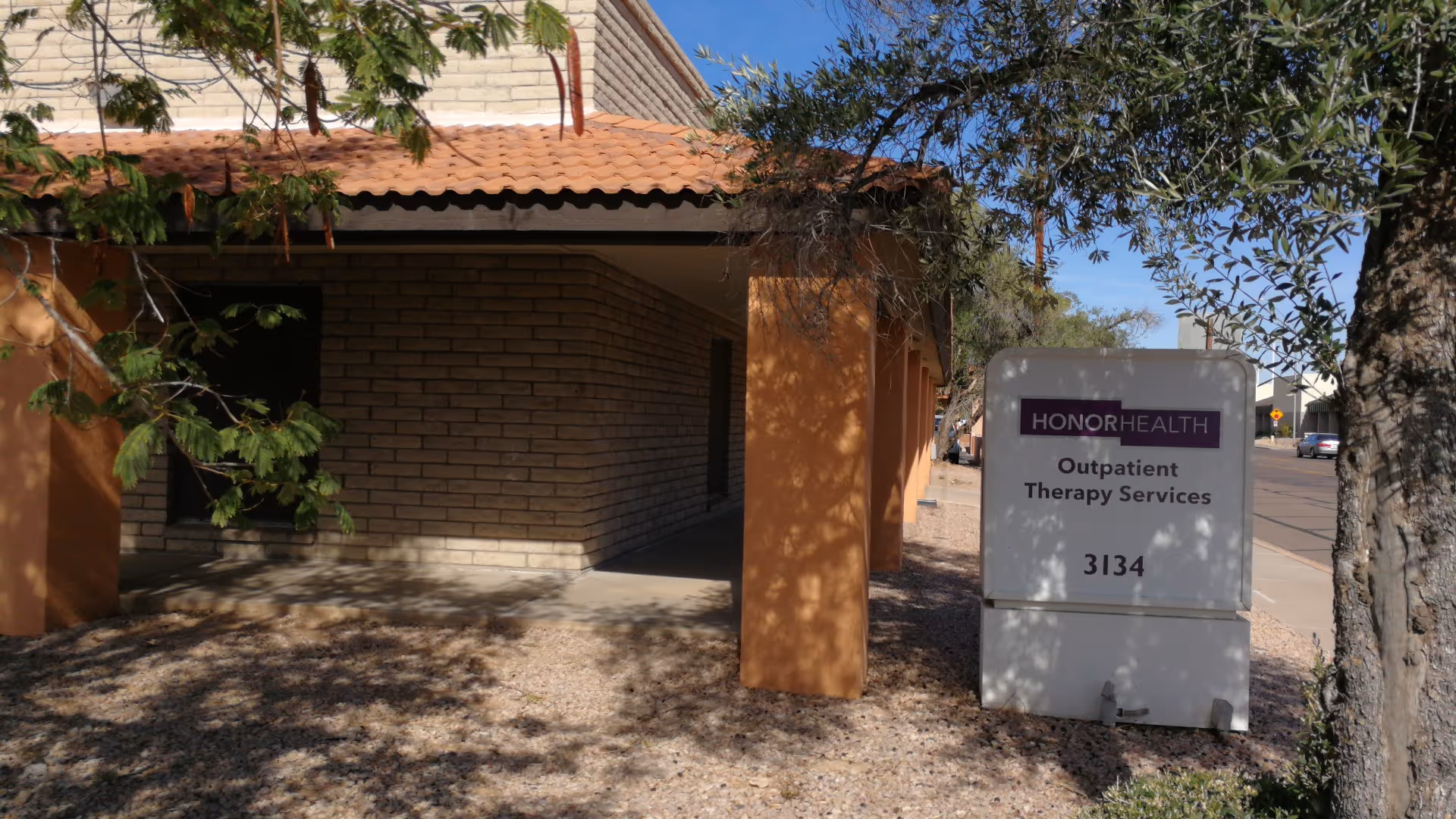 Exterior view of a brick building with a sign for HonorHealth Outpatient Therapy Services.