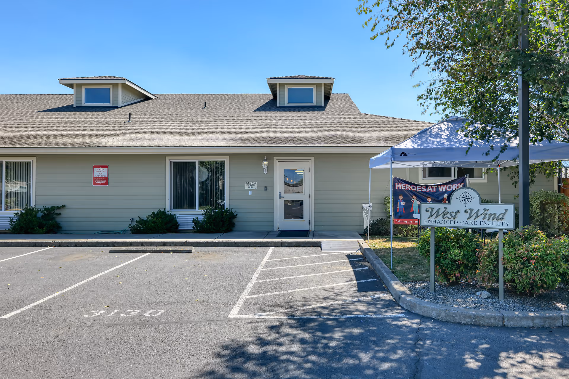 Single-story senior care facility exterior with parking and West Wind sign.