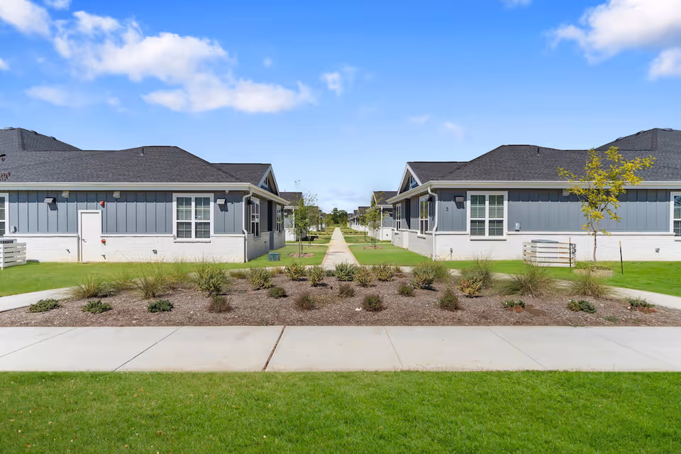 Two modern, single-story buildings flank a central walkway with landscaped front yards.