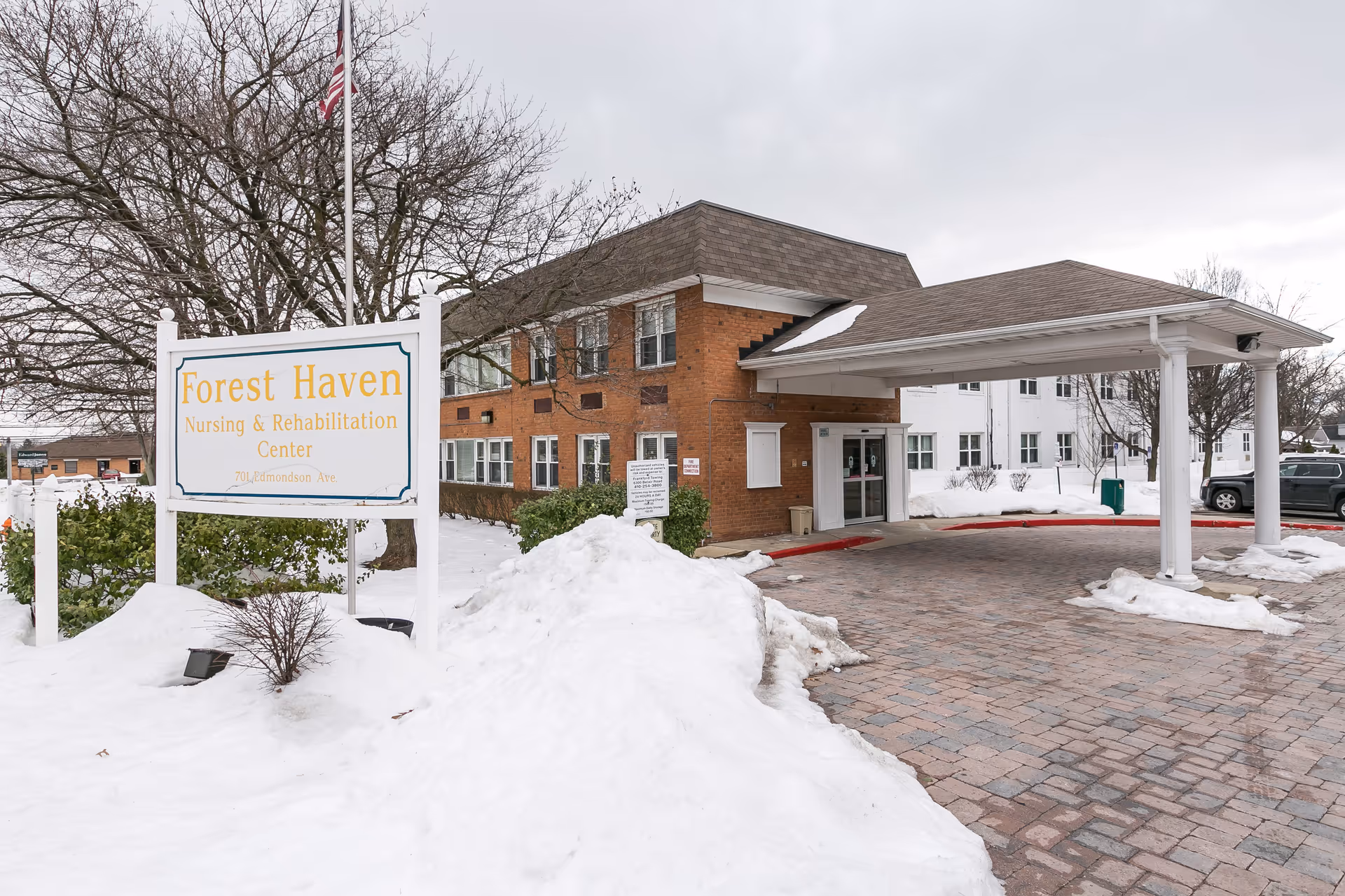 Forest Haven Nursing & Rehabilitation Center exterior with covered entrance and snow-covered grounds.