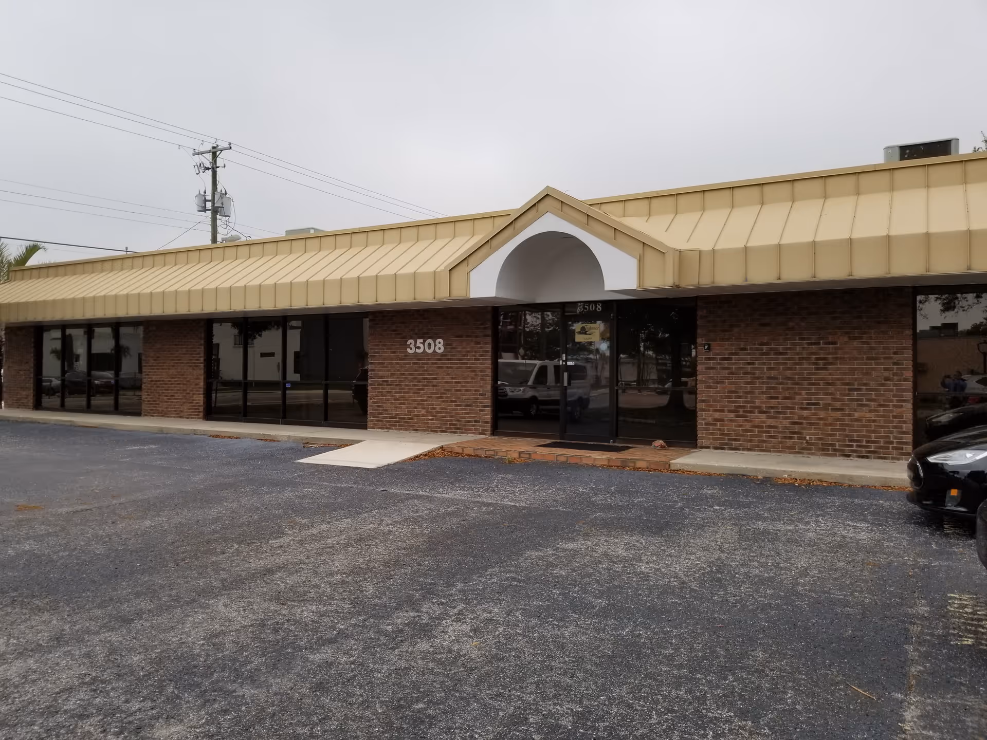 Brick storefront of Windmoor Healthcare Tampa Outpatient with glass doors under a beige awning.