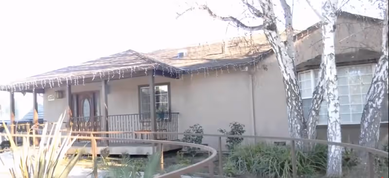 Exterior of Casa Alice Care Home, a single-story building with a porch and string lights.