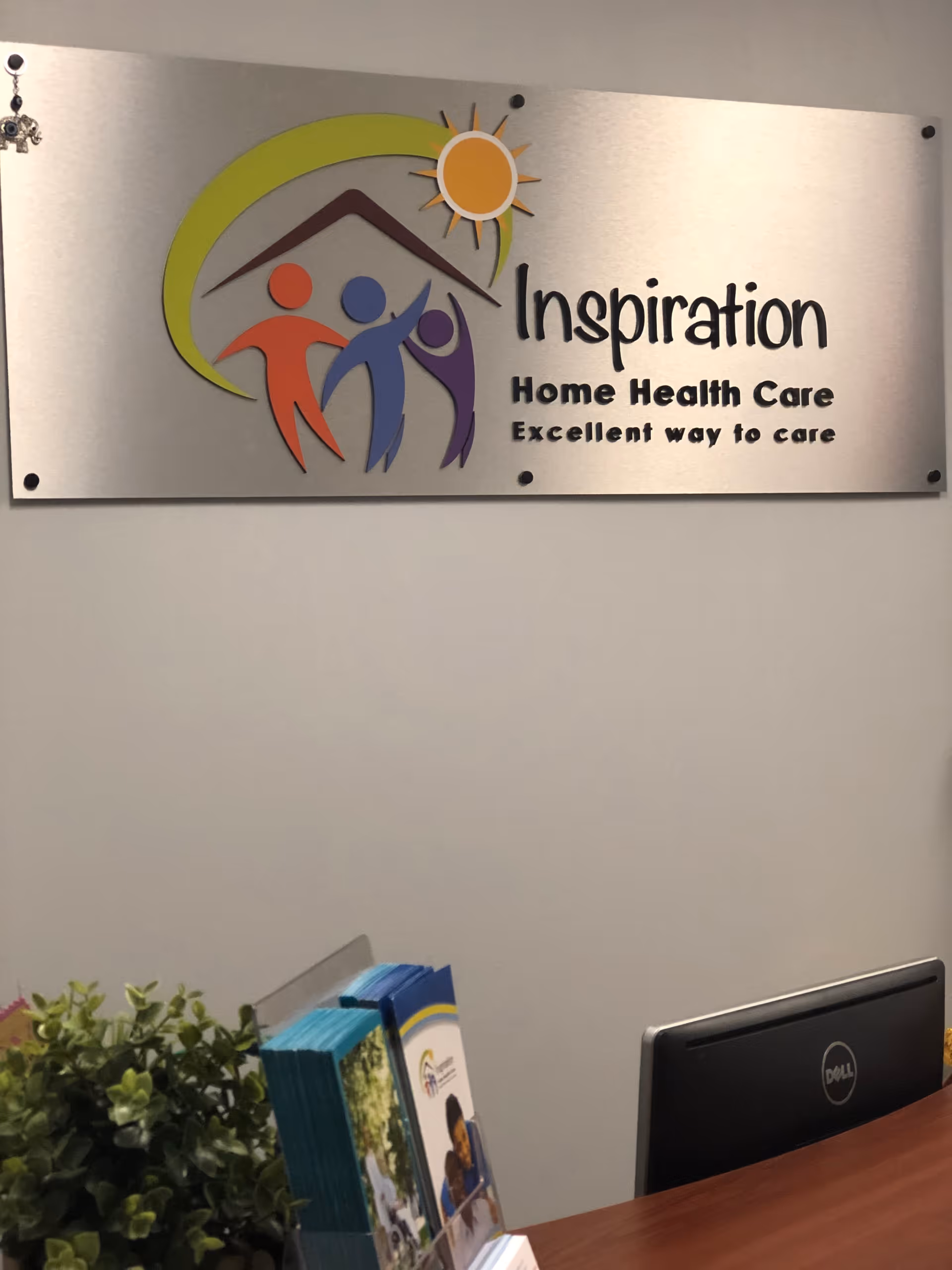 Indoor reception area with sign for Inspiration Home Health Care and a desk.