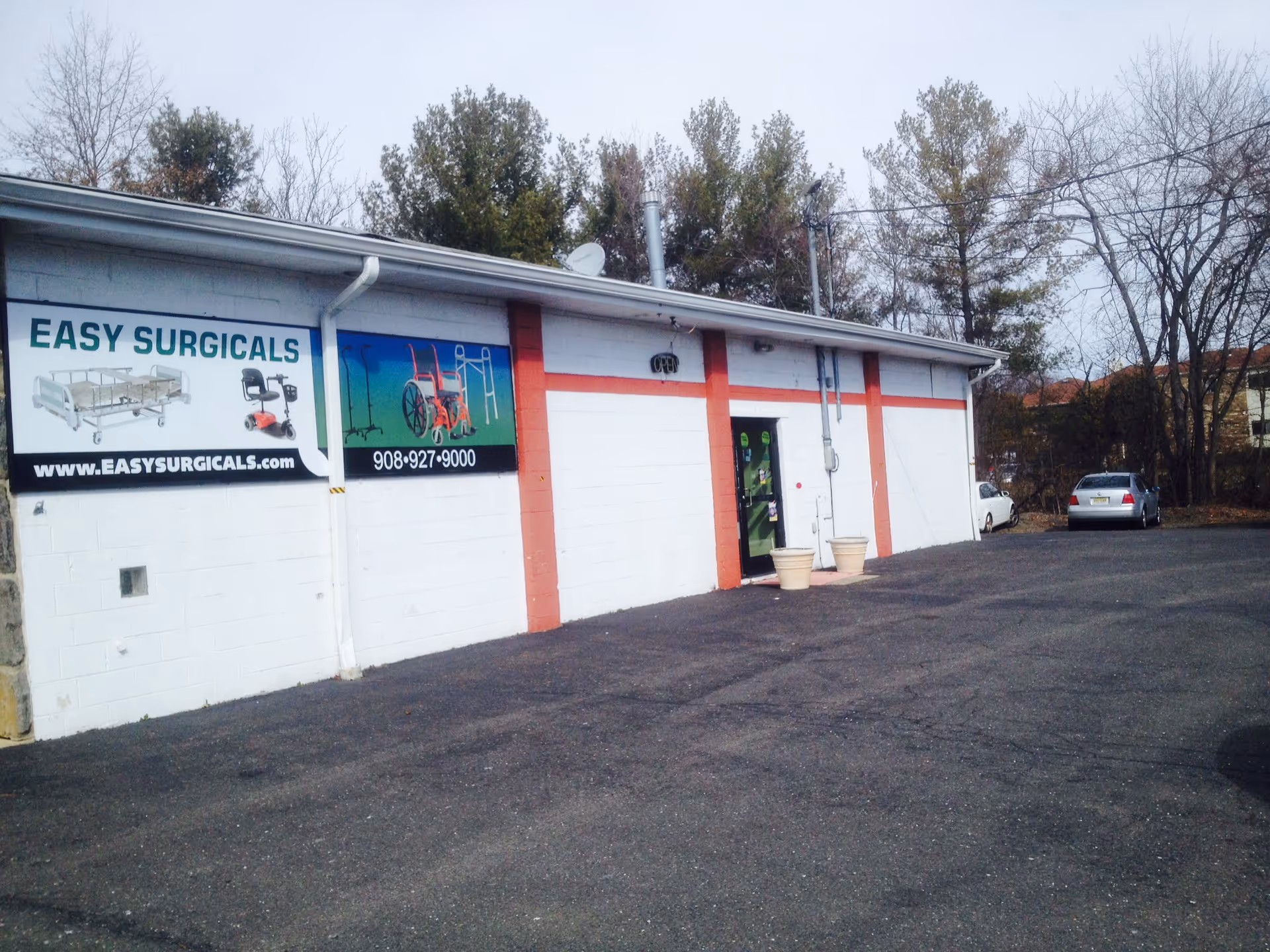 Exterior view of Easy Surgicals storefront with parking lot and signboards.