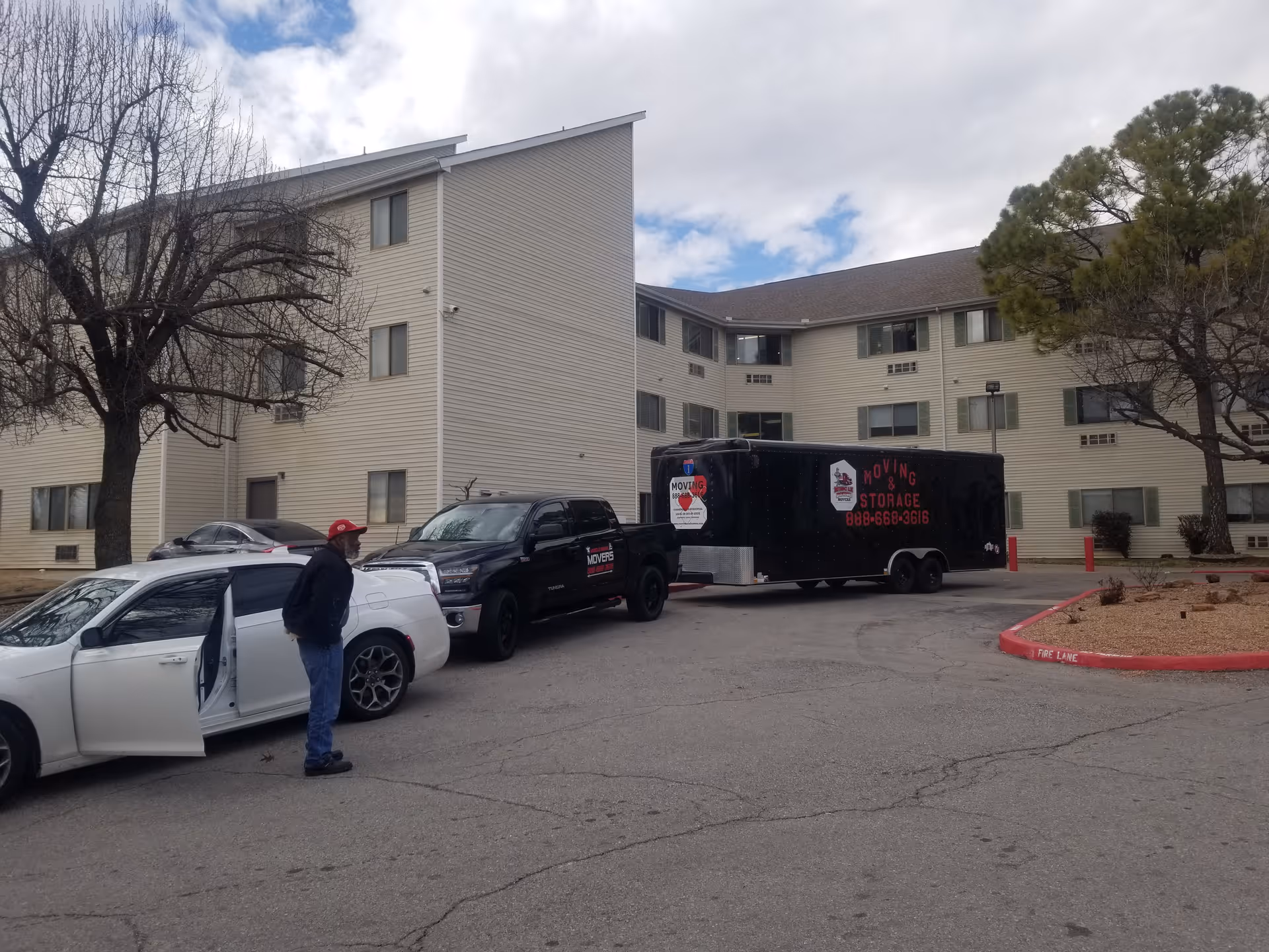 Exterior of Atkins Opportunities Garden with a moving truck and parked cars in the lot.