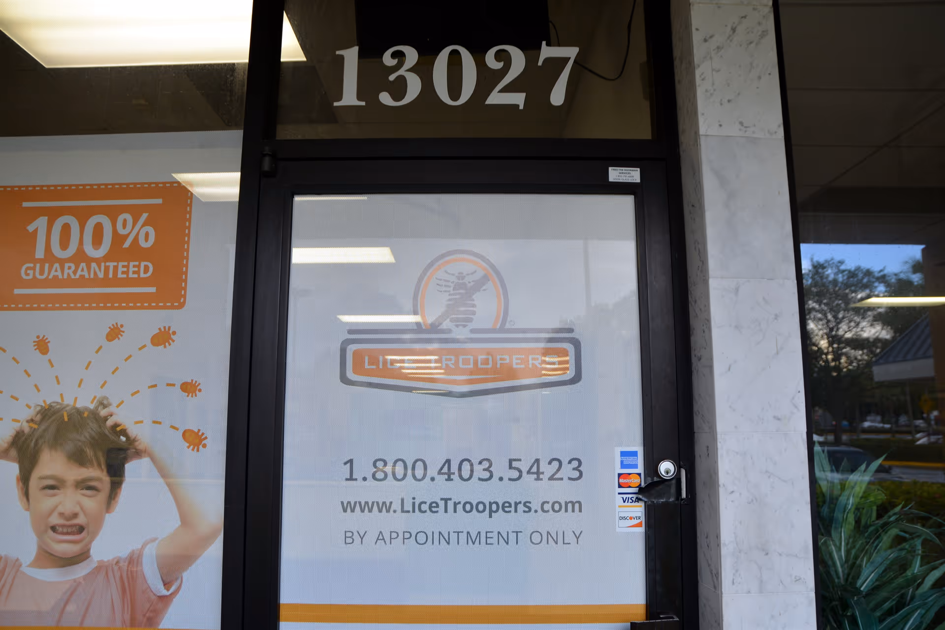 Storefront entrance of Lice Troopers clinic with logo, phone number, and appointment-only note.