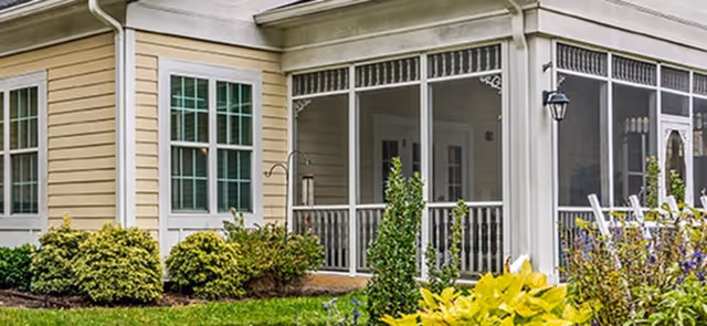 Exterior view of Cadence at Wake Forest building front with a porch and landscaped shrubs.