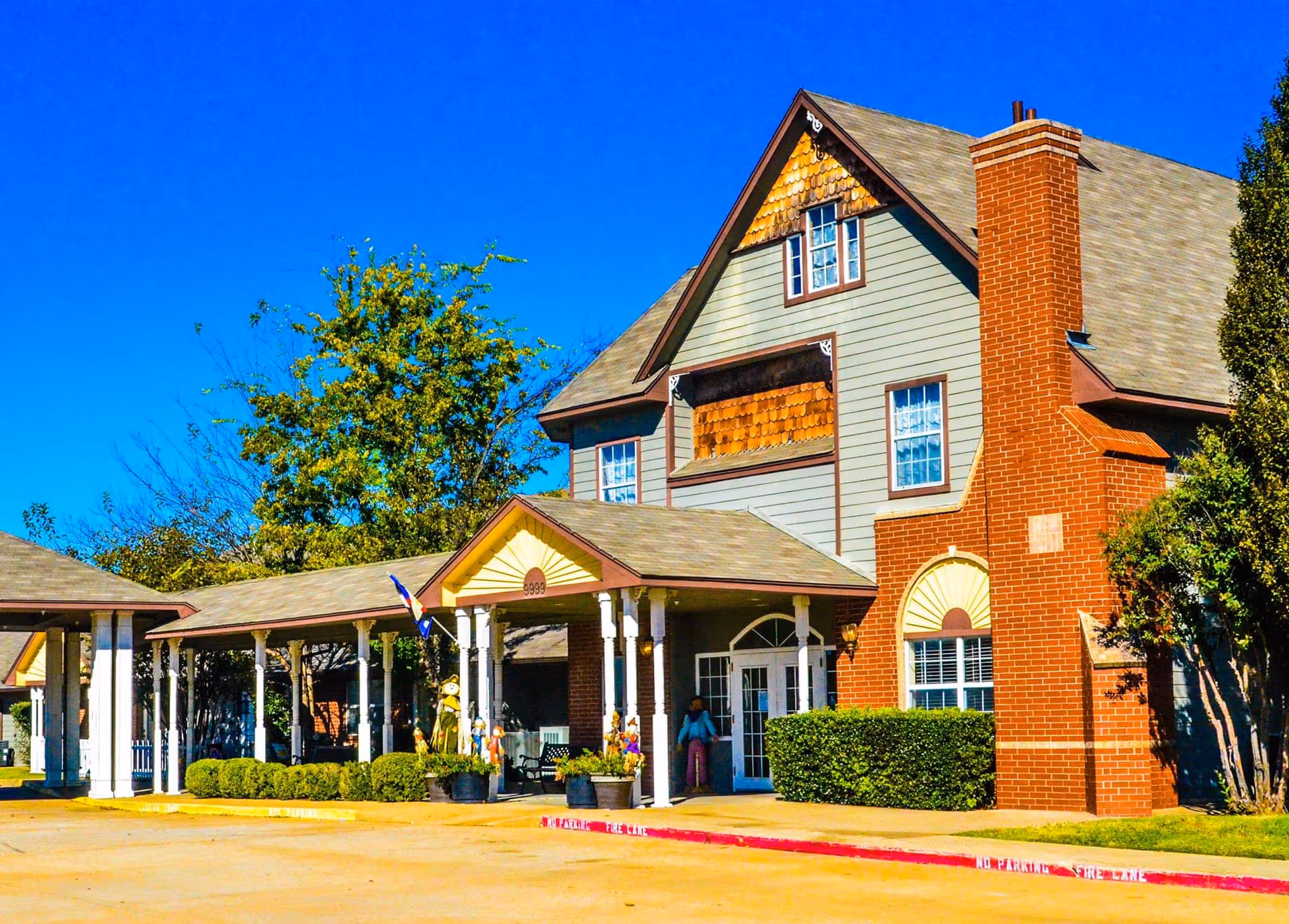 Exterior view of a senior living community building with a covered entrance.