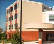 Exterior view of a multi-story hospice building with a curved entry.