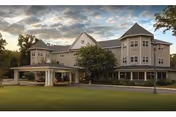 Exterior view of a beige retirement community building with a covered entrance canopy.