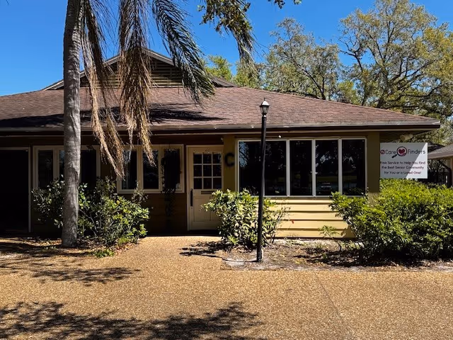 Front exterior of a My Care Finders facility with large windows, entrance, and palm trees