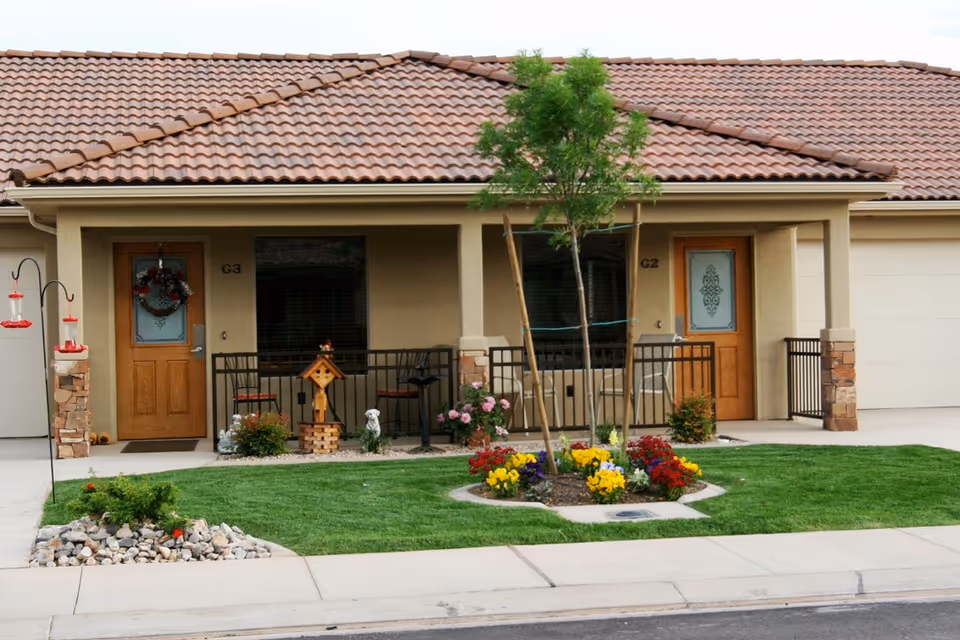Exterior of BeeHive Homes of St. George: beige building, red tile roof, front garden.