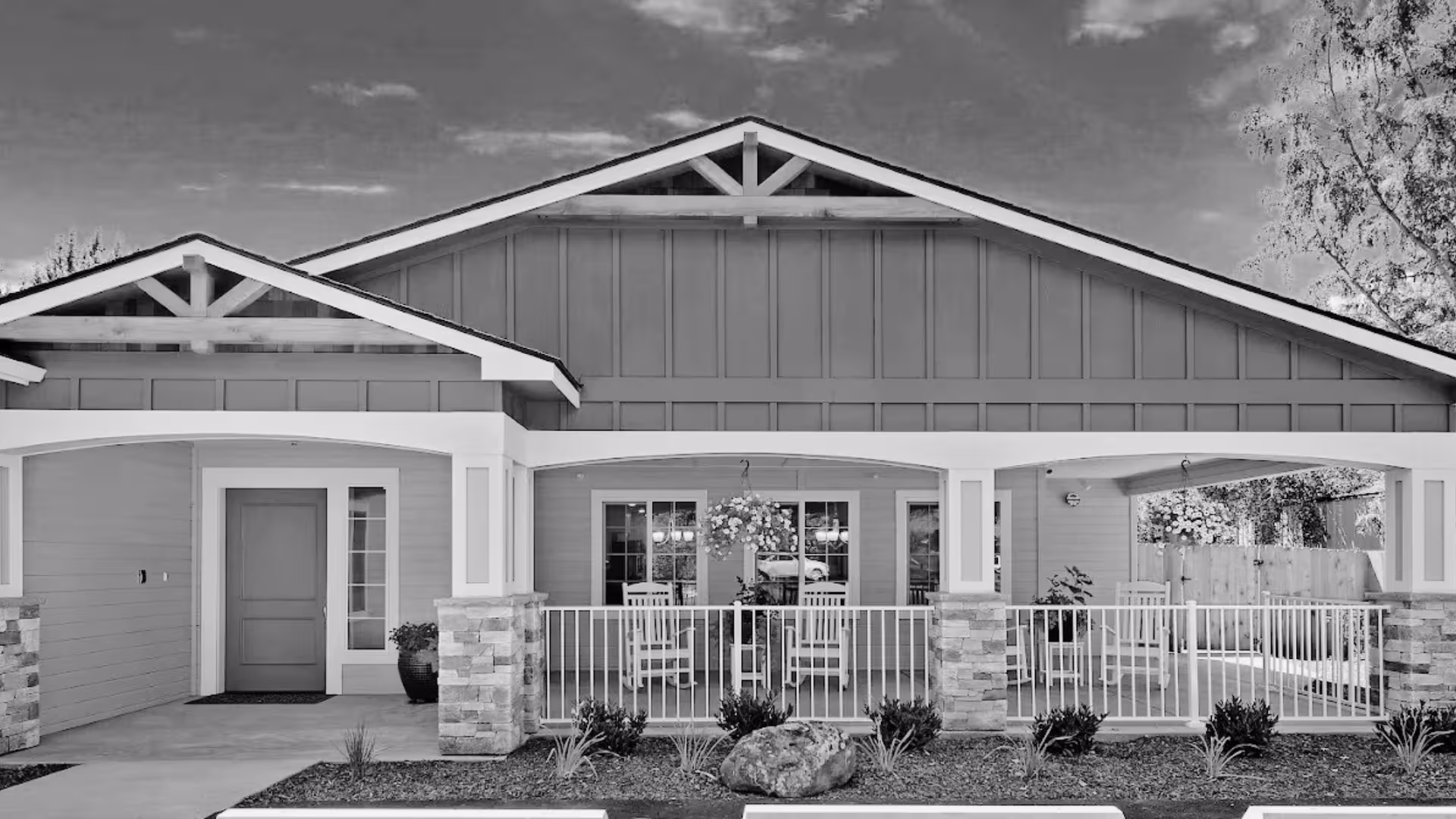 Single-story care facility exterior with a covered porch and outdoor seating.