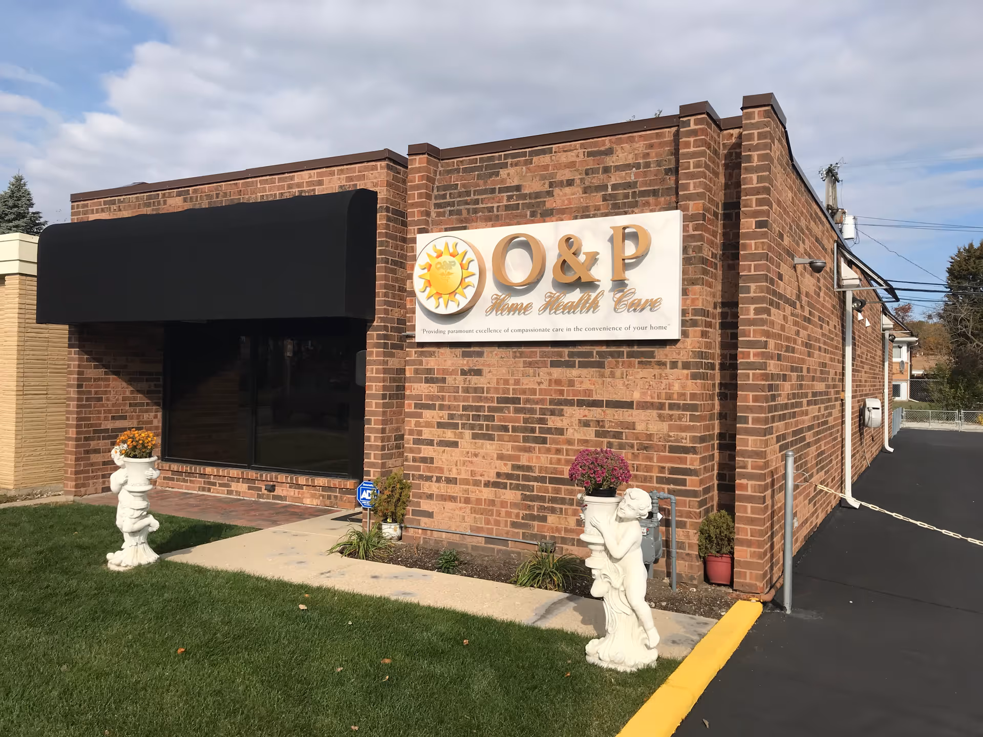 Brick building exterior with a large O&P Home Health Care sign and decorative statues.