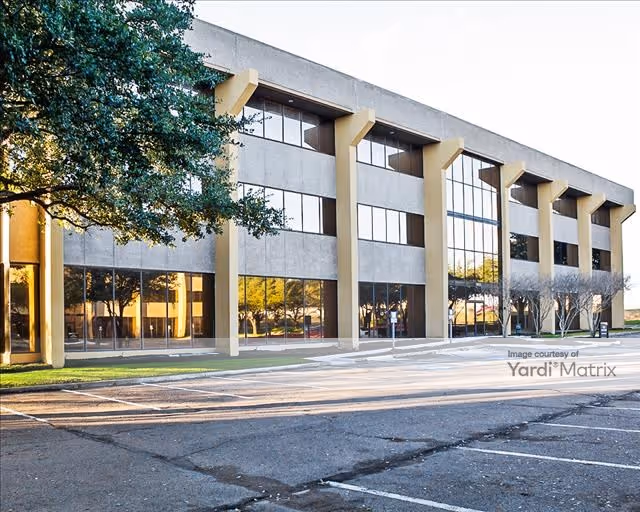 Front exterior of a modern building with large windows and beige columns