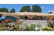 Exterior view of Hildebrand Care Center with cars parked and blooming flower beds in front.