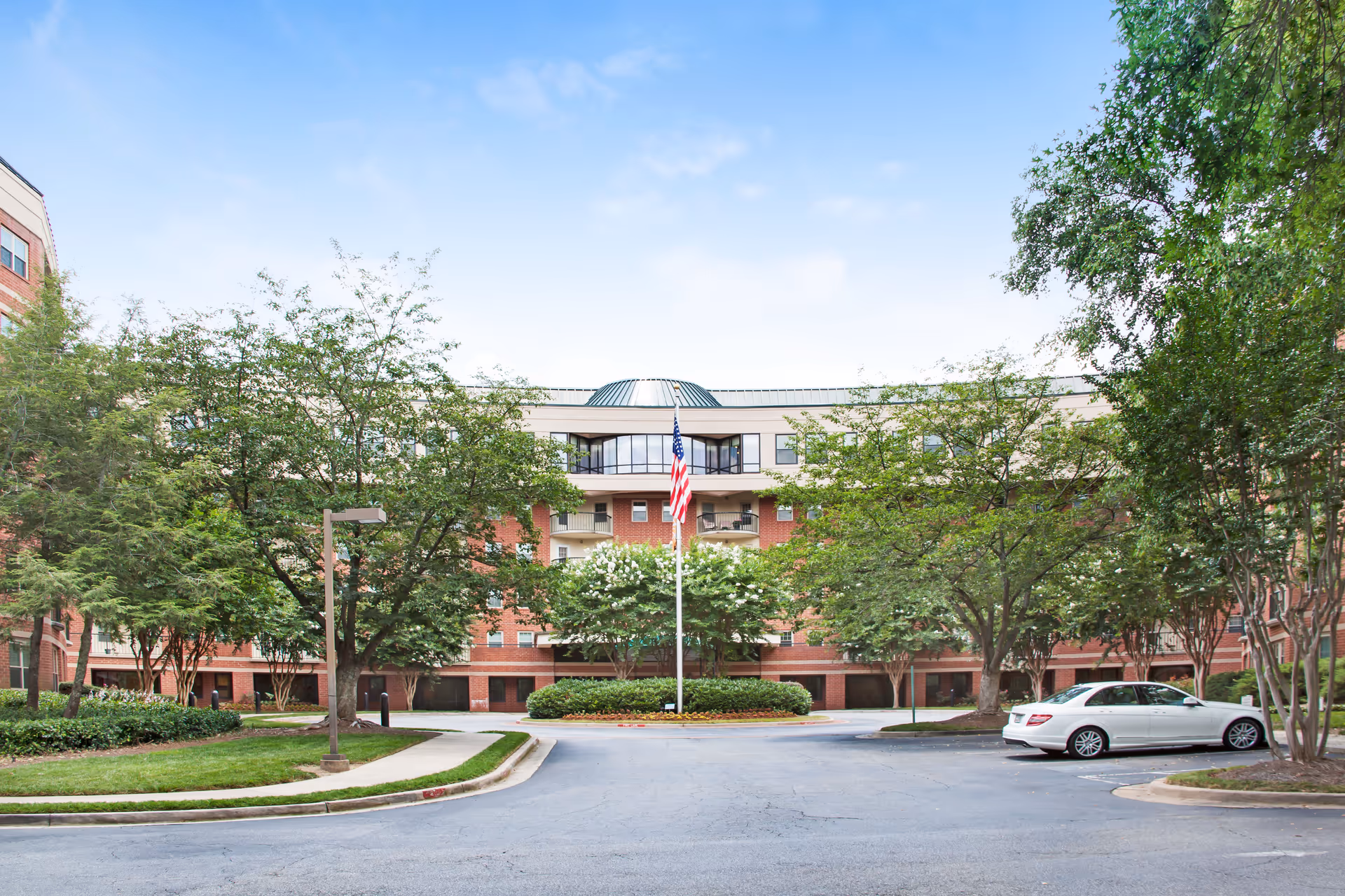 Exterior view of Sunrise at Huntcliff Summit I, a brick senior living building with trees.