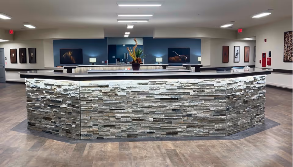 Curved stone reception desk in a modern indoor lobby at Avir at Kerrville.