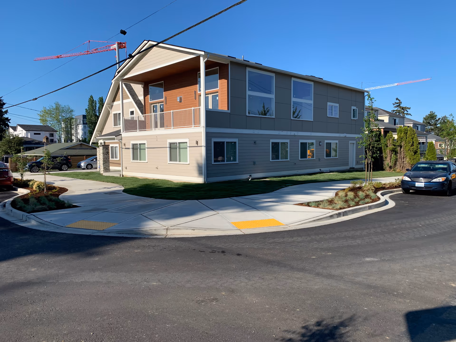 Modern two-story adult family home building with curved driveway and landscaping.