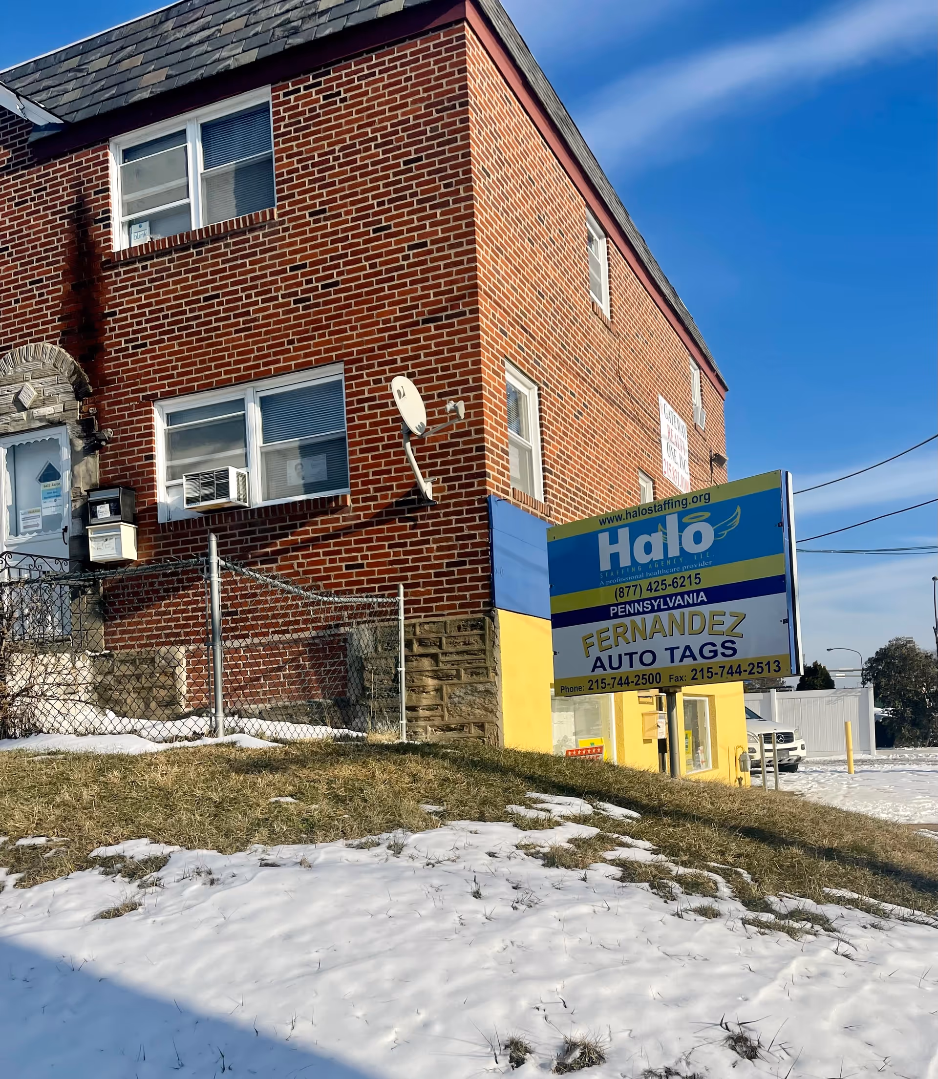 Brick building with Halo Staffing Agency sign and snow-covered ground.