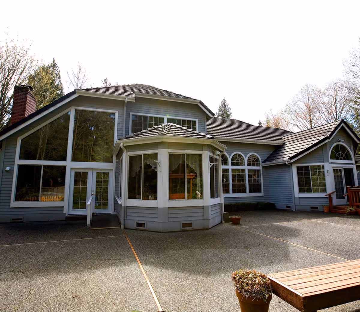 Exterior view of a blue multi-section adult family home with large windows.