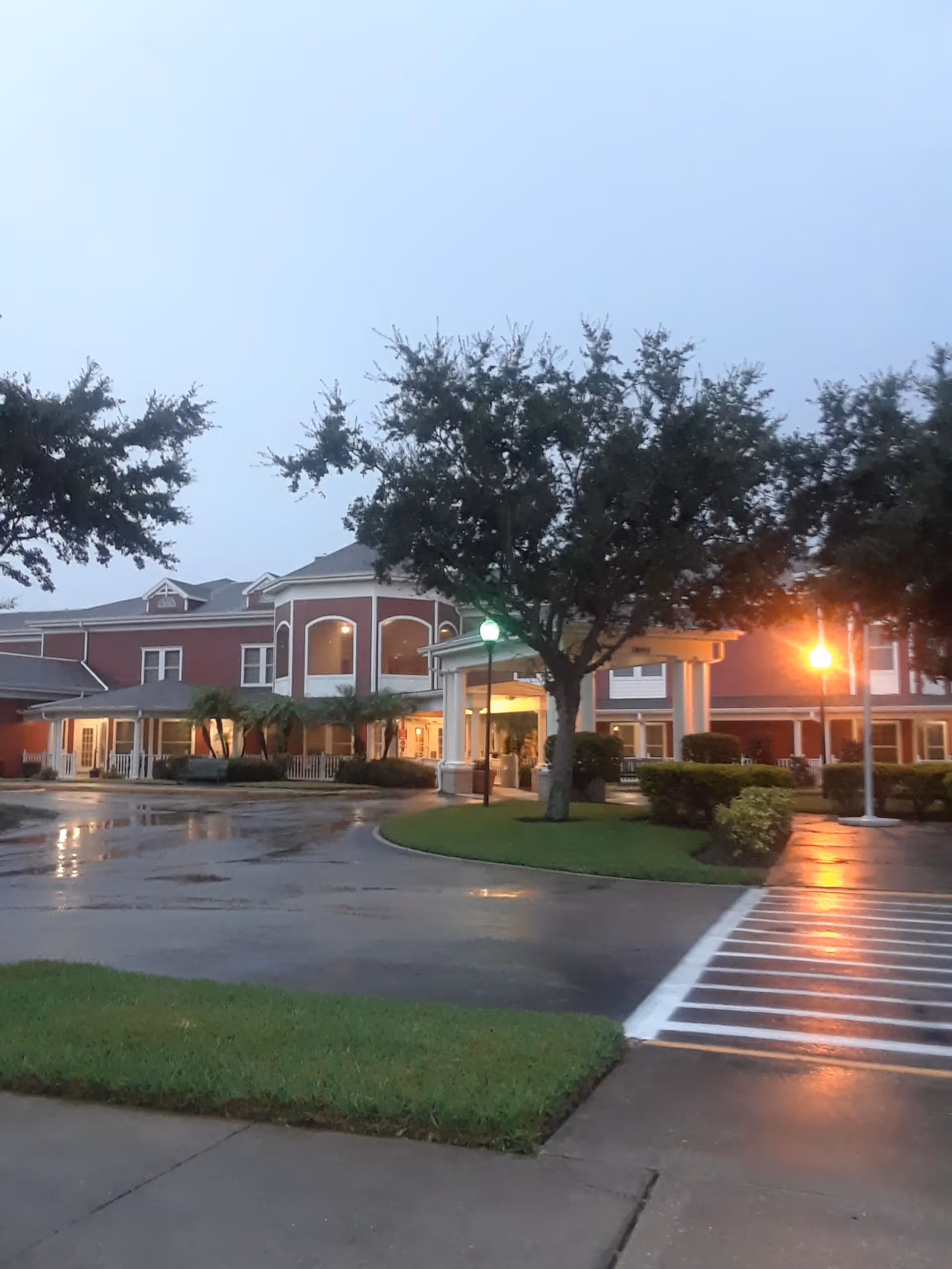 Exterior view of Bedrock at Home Orlando with trees, entrance, and wet pavement.