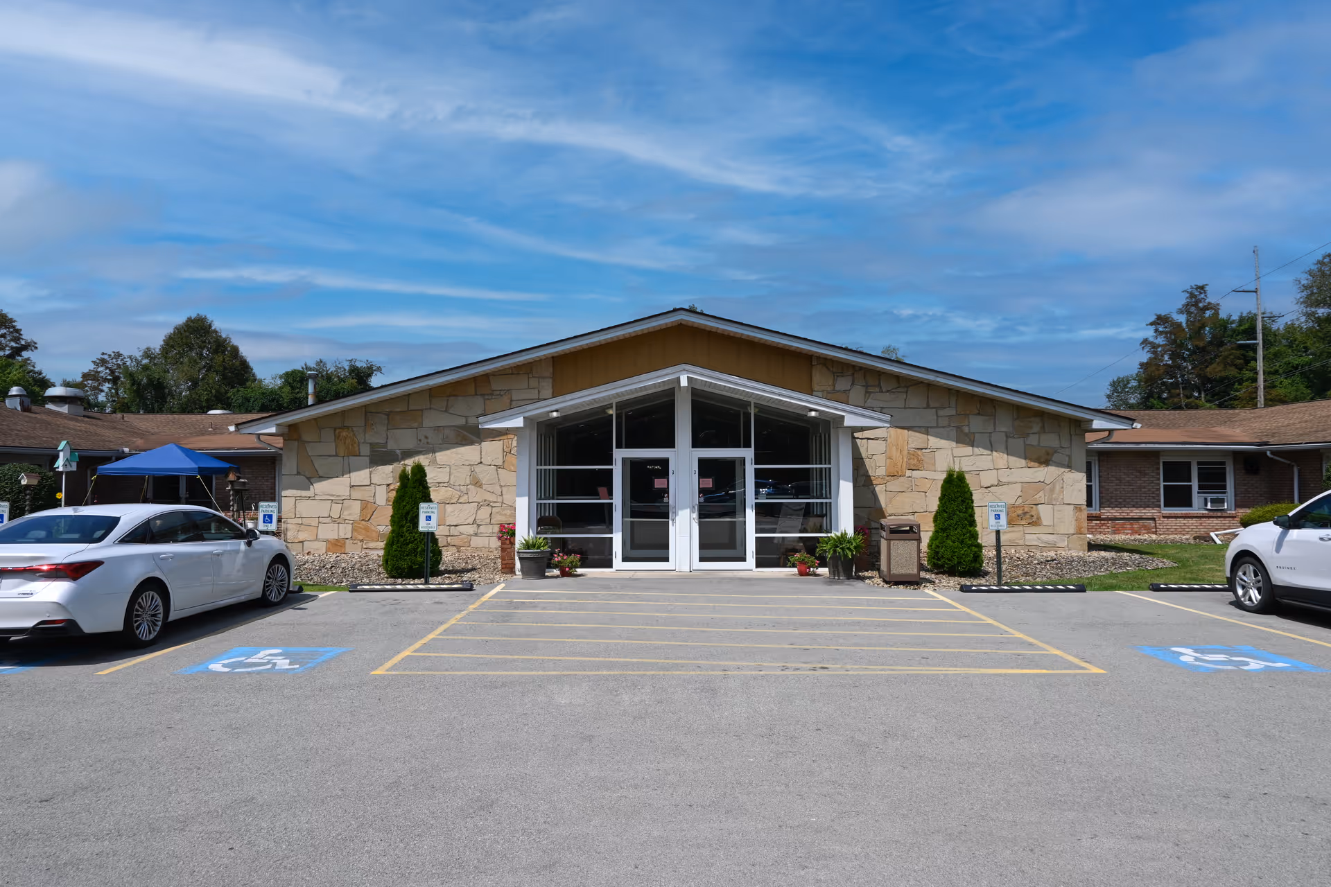 Front view of Twin Lakes Rehabilitation and Healthcare Center with stone facade and parking