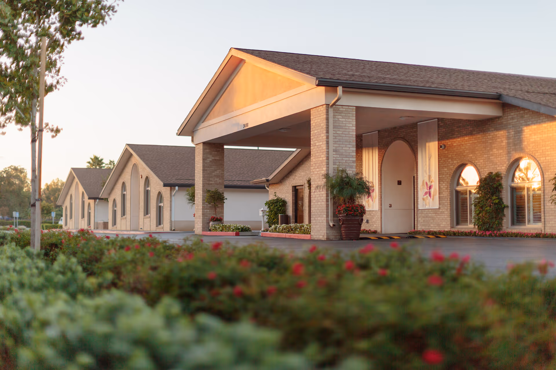 Exterior view of a senior care center with arched windows and landscaped entrance.