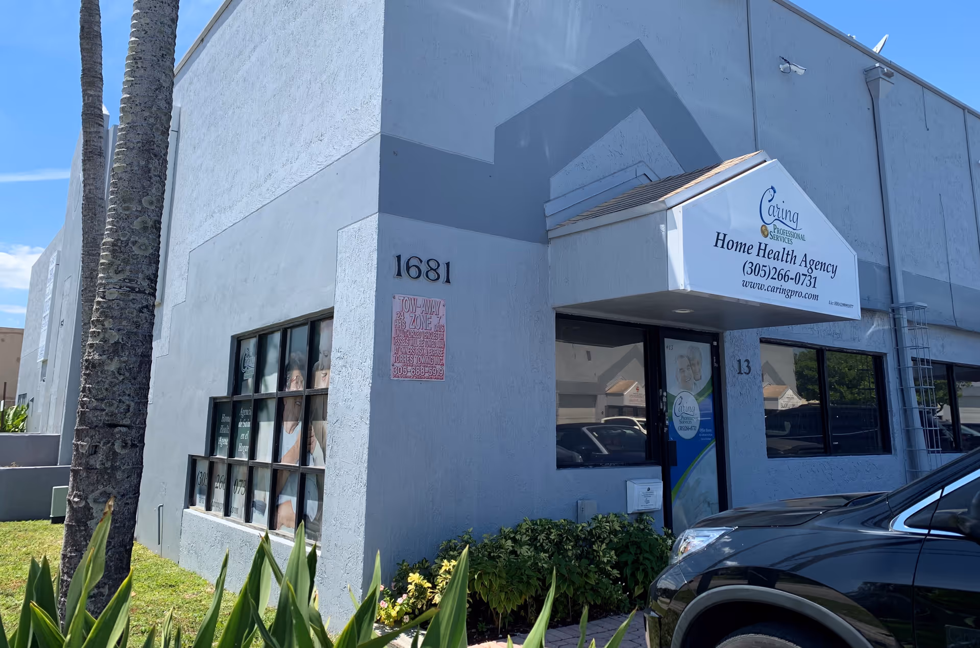 Light blue-gray building front with Home Health Agency sign and parked car.