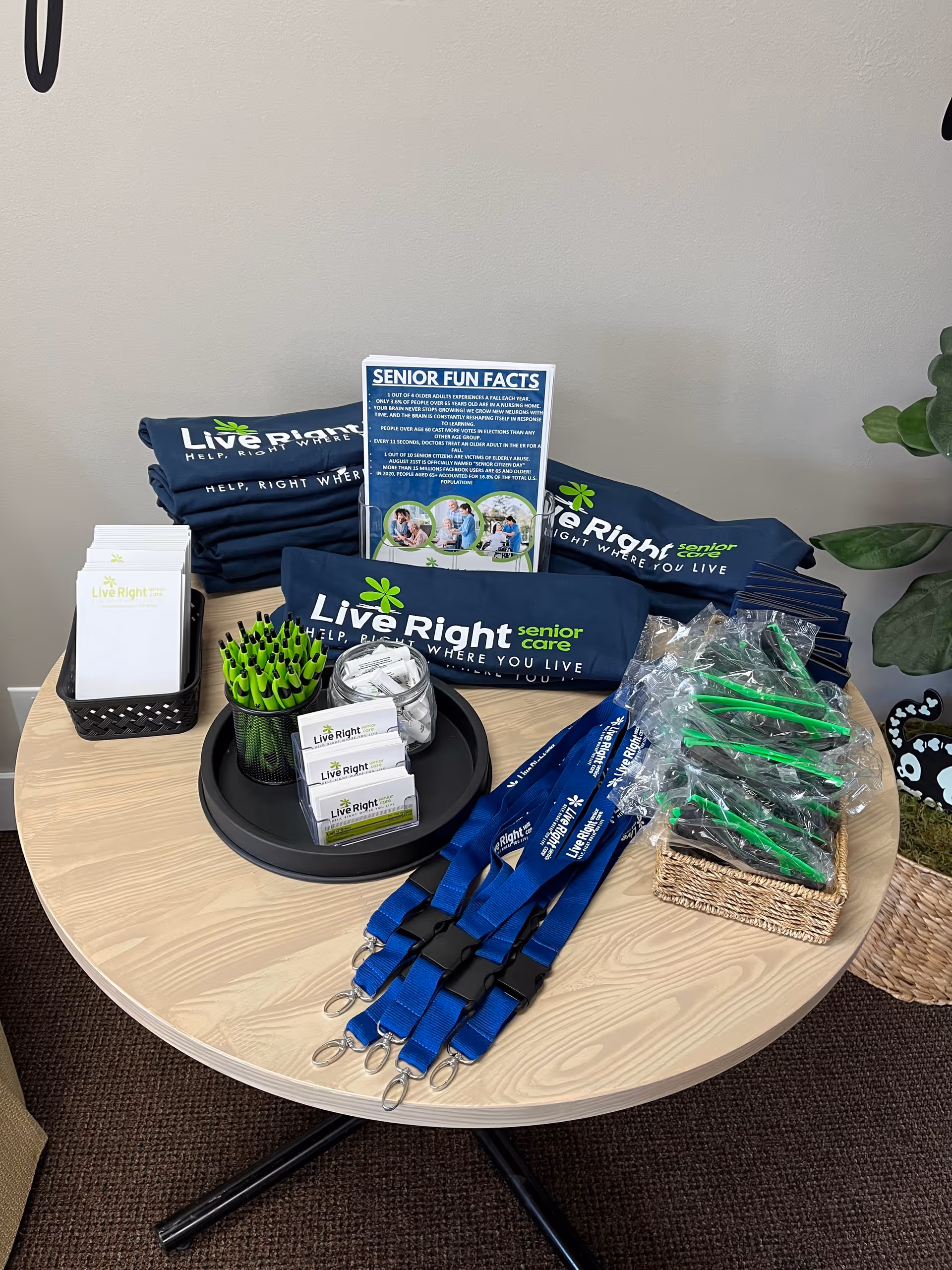 Promotional display on a round table featuring Live Right Senior Care materials and lanyards.