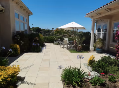 Villa Ambrosia outdoor patio between buildings with seating under a white umbrella