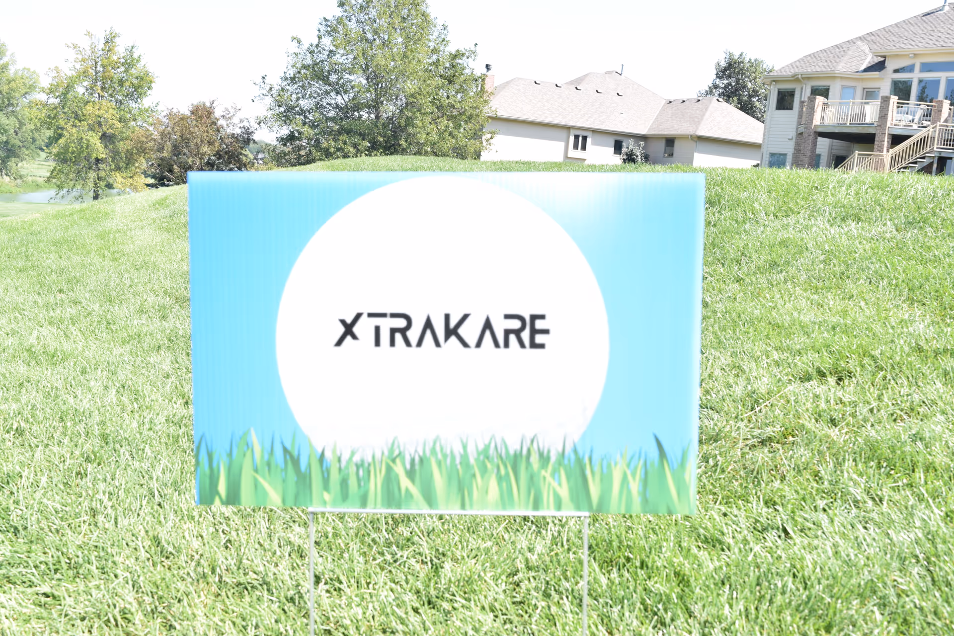 Outdoor grassy area with a sign displaying XTRAKARE Home Care Service