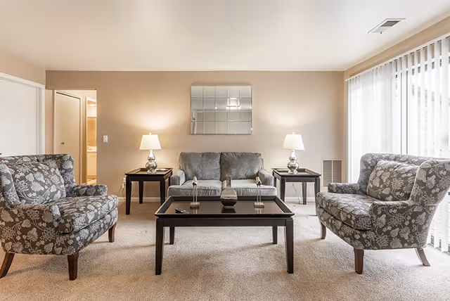 Tipton Hills Adult Foster living room with central coffee table, sofa, floral chairs, and lamps.