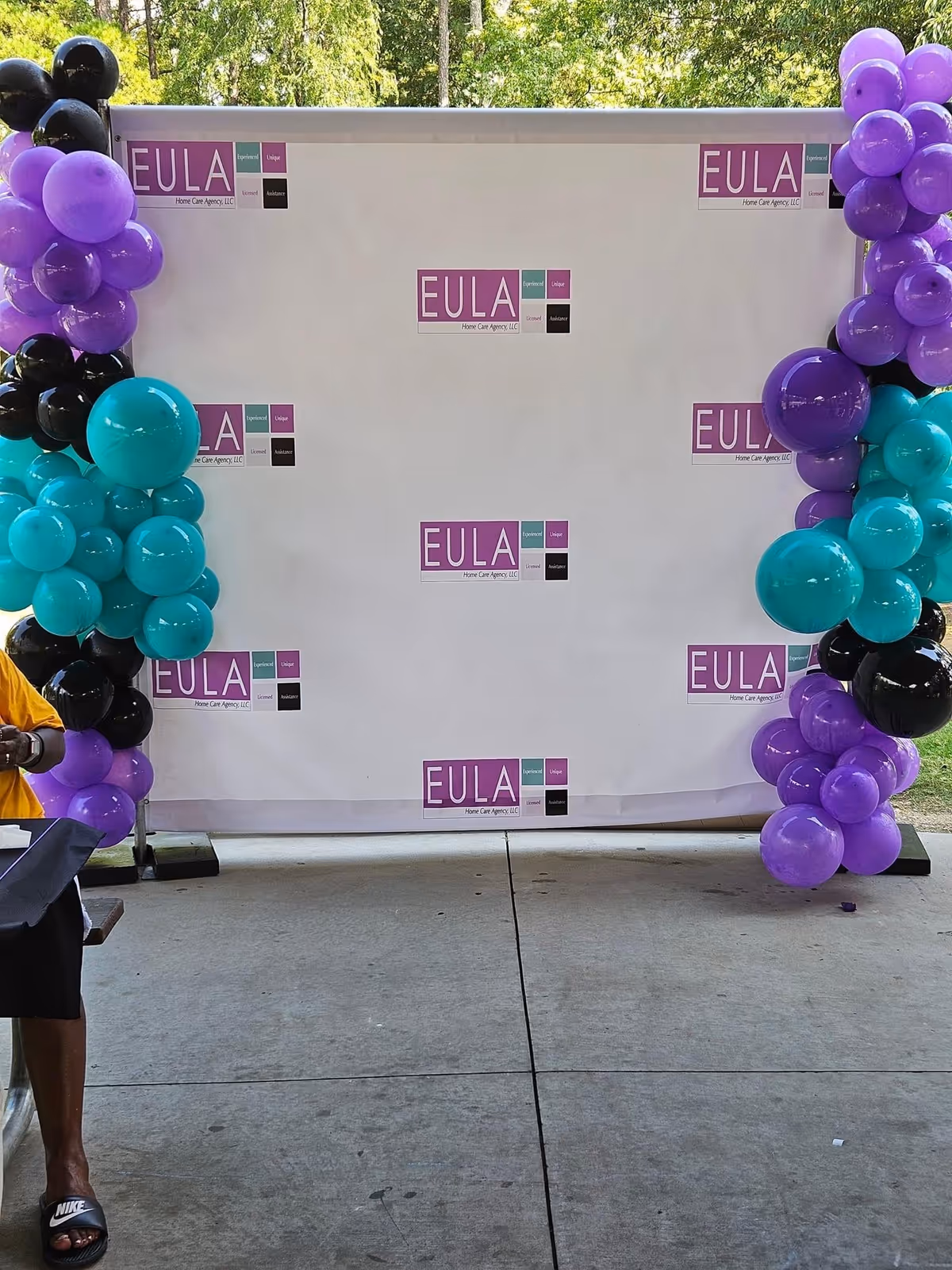 Outdoor event backdrop with EULA logos and balloon arches on both sides.