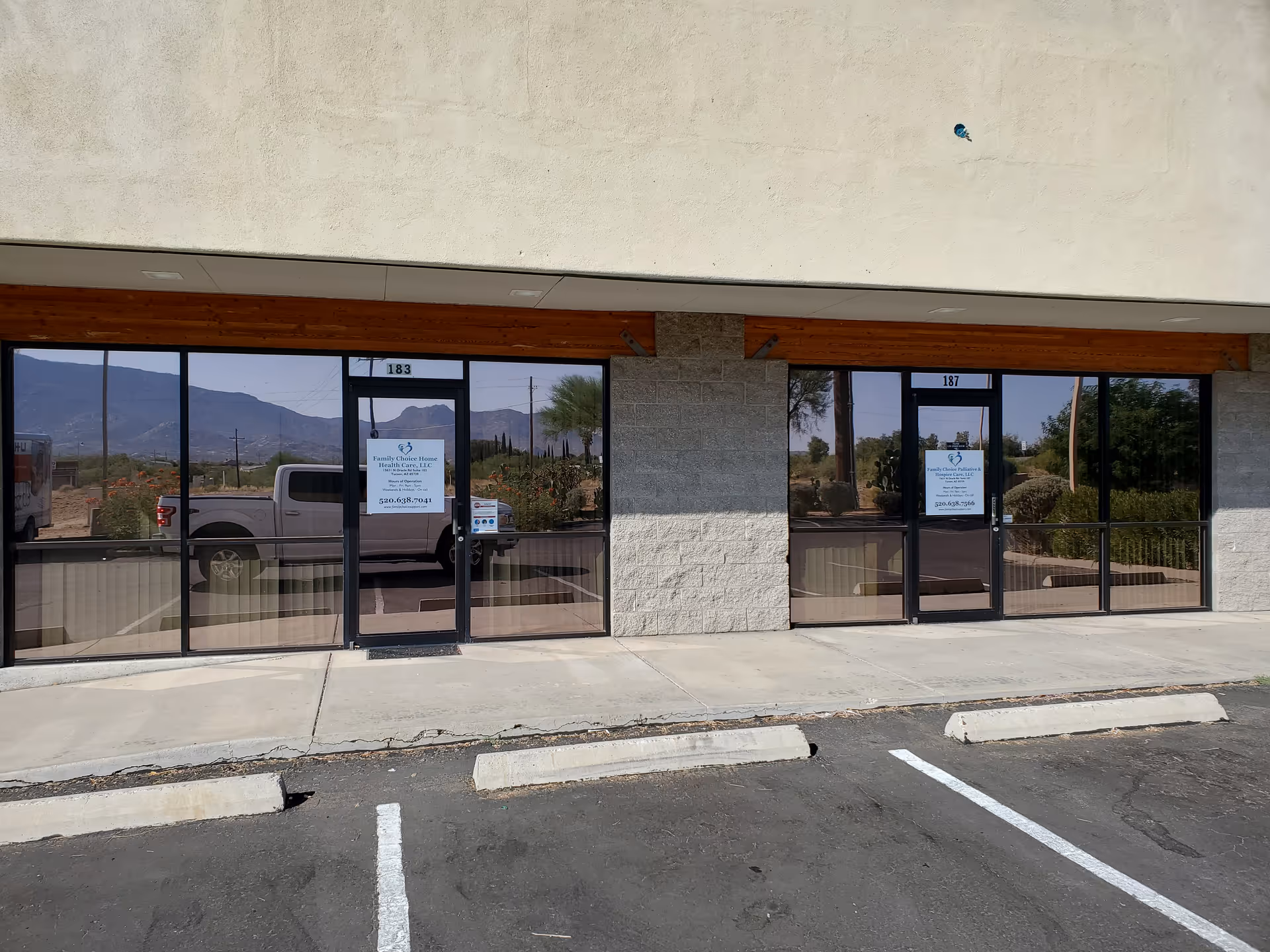 Exterior view of a storefront with glass doors and signs for a care facility.