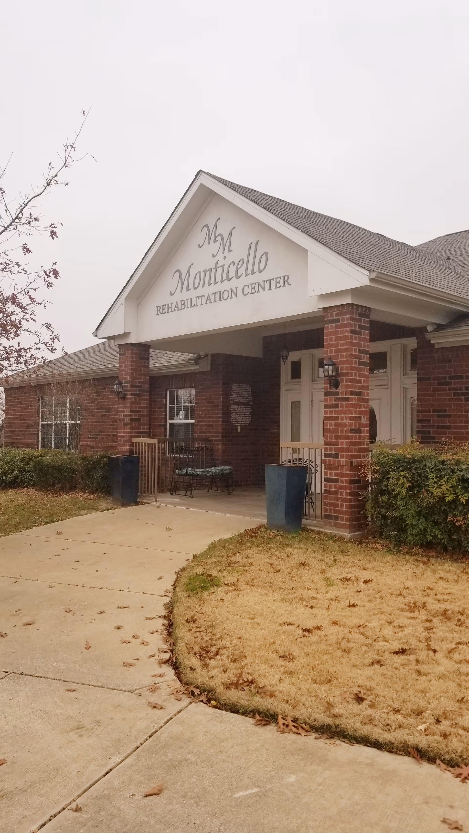 Brick building entrance with a gabled sign and columns, labeled Monticello Rehabilitation Center.