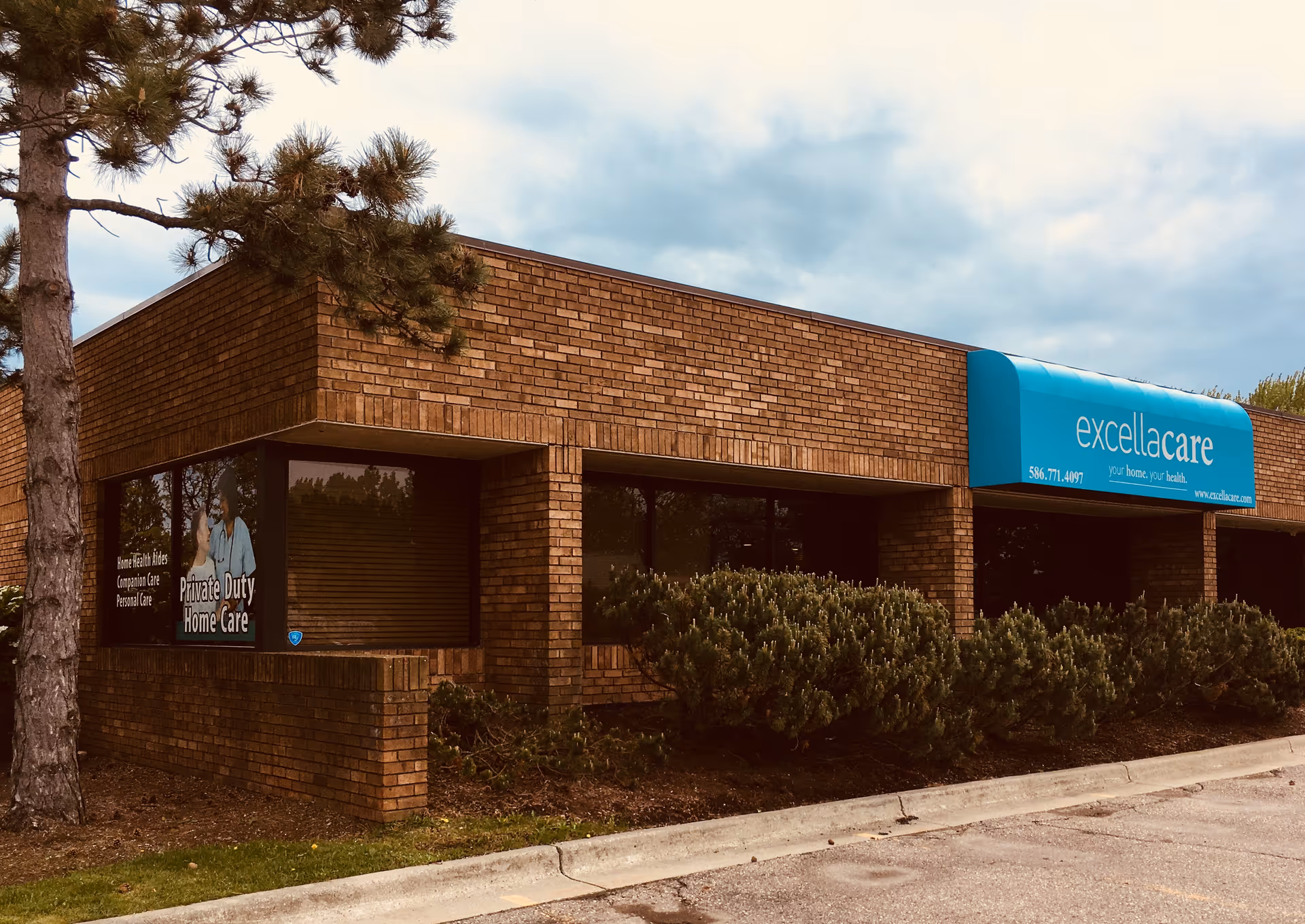 Brick exterior of Excellacare Home Health Care with a blue sign.