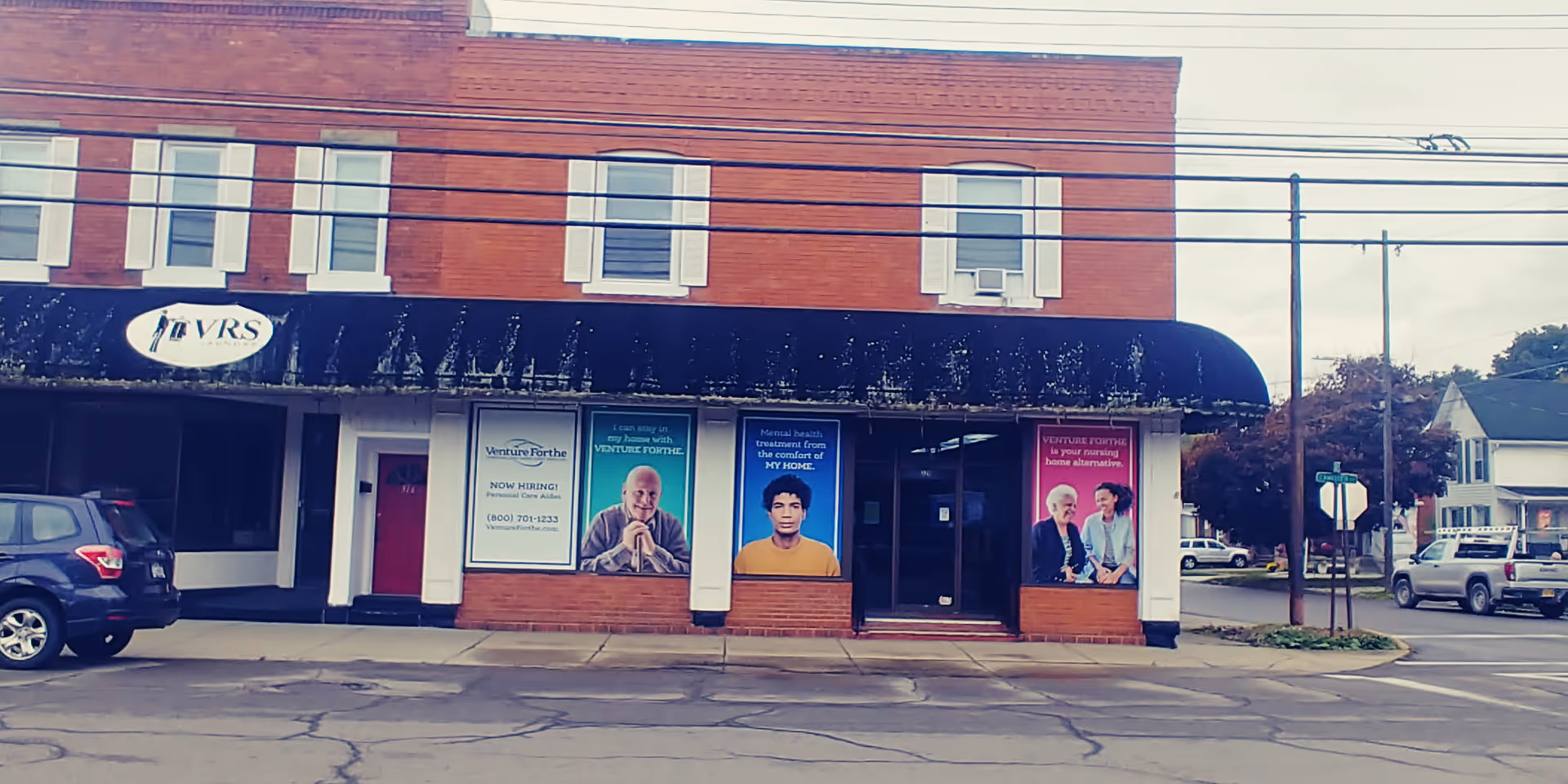Brick storefront with black awning and posters for Venture Forthe Hornell Training Center.