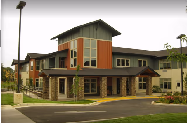 Front exterior view of The Vistas Assisted Living and Memory Care building with stone pillars.