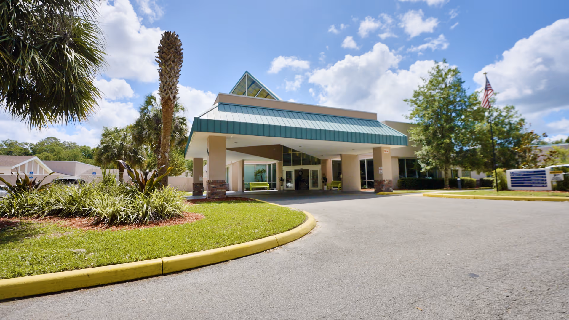 Exterior view of Terrace Health & Rehabilitation Center with a covered entrance and landscaped surroundings.