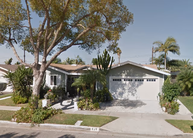 Residential single-story home with driveway, garage, and landscaped front yard.