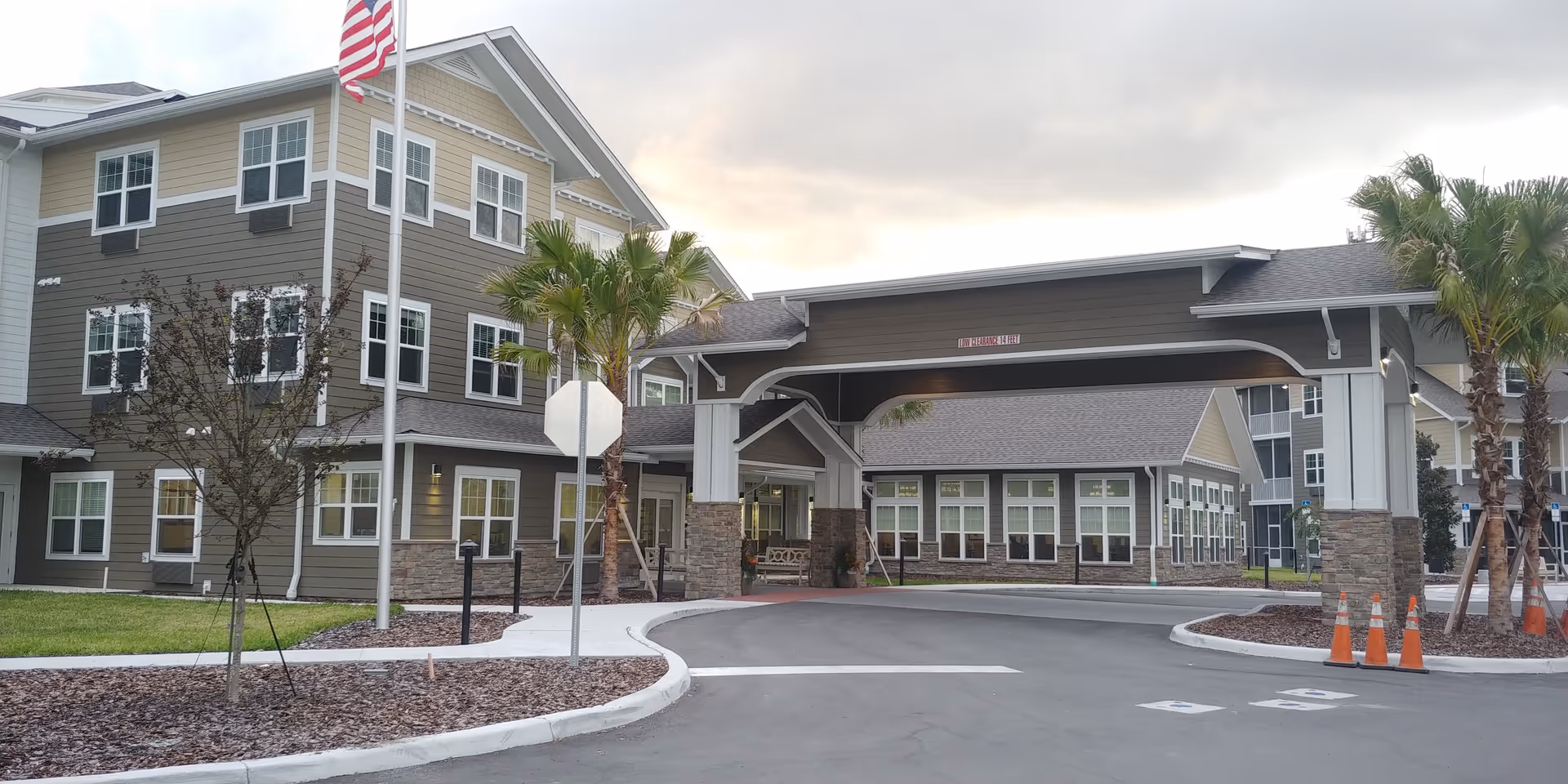 Exterior view of Osprey Heights retirement living facility with covered entrance and palm trees