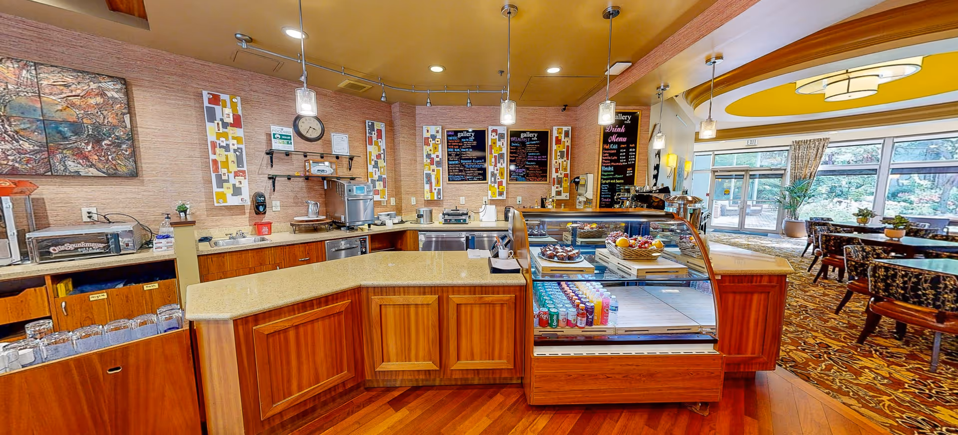 Interior cafe-style dining area with a curved counter, pastry display, and seating.