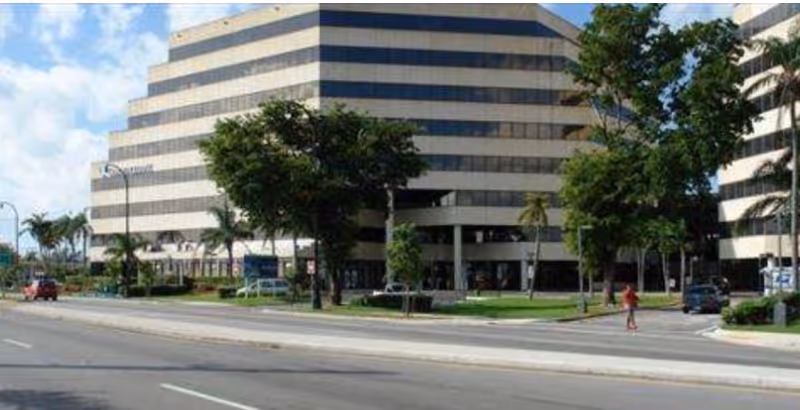 Exterior view of a multi-story building along a busy street.